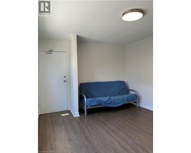 A bedroom with a bed covered in a blue sheet and a white door.