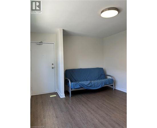 A bedroom with a bed covered in a blue sheet and a white door.