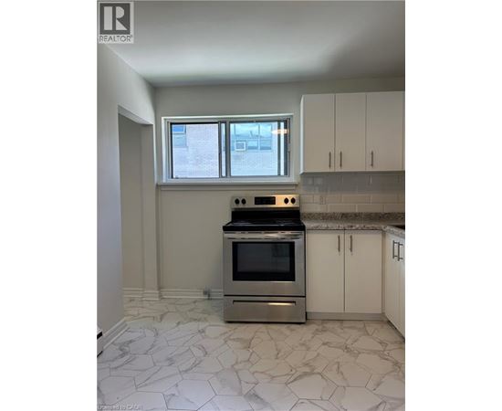 A kitchen with a stove top oven and a window.