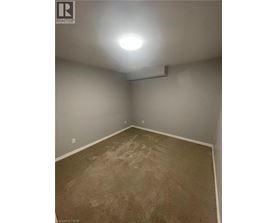 A room with carpeted floor and a light on the ceiling.