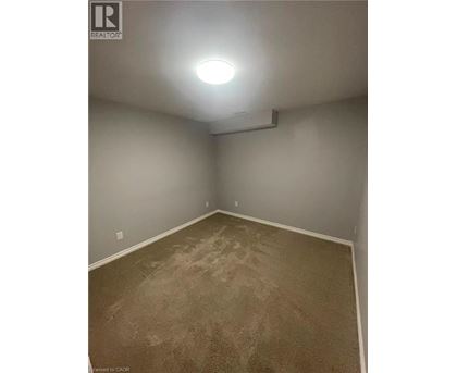 A room with carpeted floor and a light on the ceiling.