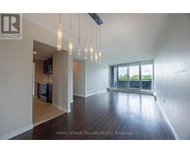 A spacious room with wooden floors and a large window.