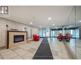 A spacious living room with a fireplace and a red chair.