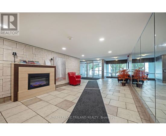 A spacious living room with a fireplace and a red chair.