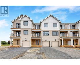 A large, modern two-story residential building with multiple balconies and garage doors.