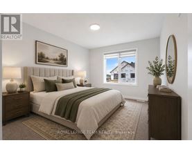 A bedroom with a large bed, a nightstand, and a framed picture on the wall.