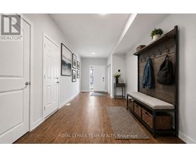 A hallway with a bench and coat rack.
