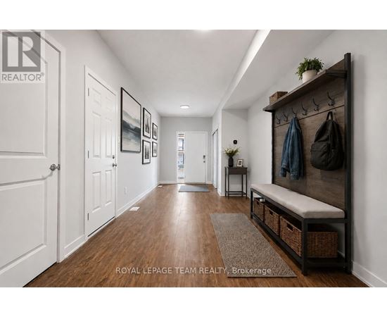 A hallway with a bench and coat rack.