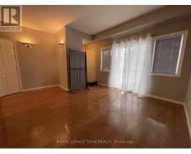 A room with wooden flooring and a white curtain.