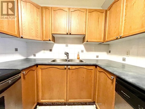 A kitchen with wooden cabinets and a sink.