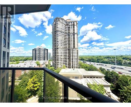 A view from a balcony overlooking a highway and buildings.