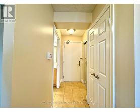 A hallway with a white door on the right and a white wall on the left.