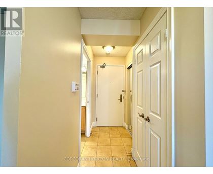 A hallway with a white door on the right and a white wall on the left.