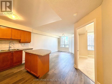 A kitchen with wooden cabinets and a countertop is shown.