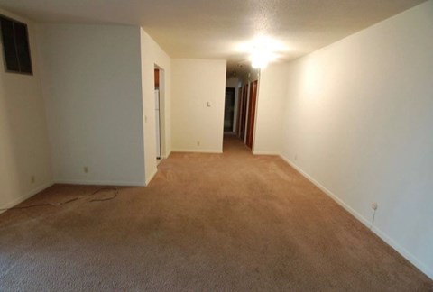 A long hallway with carpeted floors and white walls.