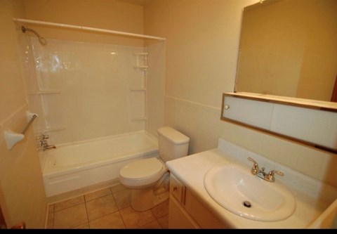 A bathroom with a toilet, sink, and bathtub.