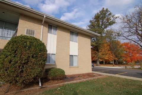 A building with a green bush in front of it.