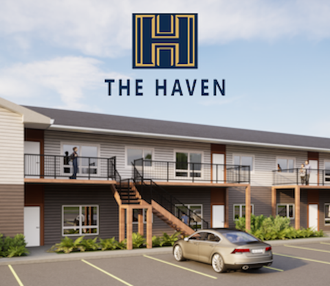 A car is parked in a parking lot in front of a building with a sign that says "The Haven.".