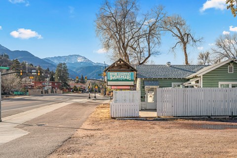 A road with a sign that says "Lodge" in front of a house.