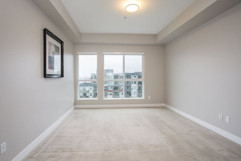 A spacious room with a large window overlooking a cityscape.