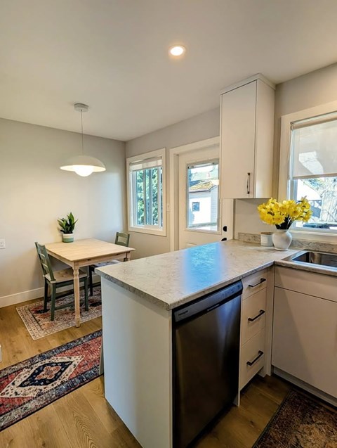 A kitchen with a dining table and chairs.