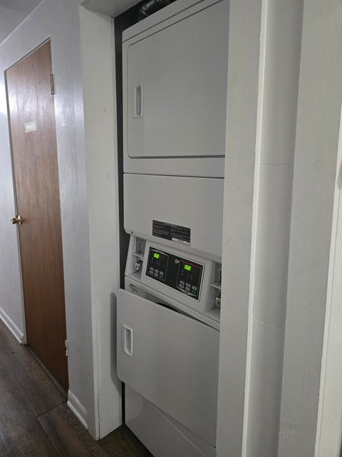 A white oven with a digital display is installed in a narrow kitchen space.