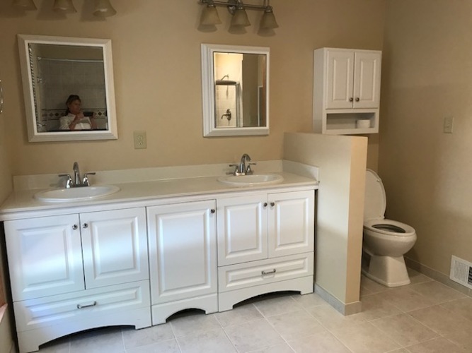 A bathroom with a white vanity and a toilet.