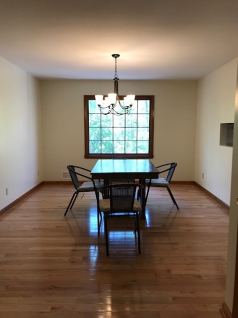 A dining room with a table and chairs.