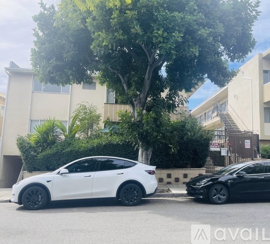 Two cars parked on the street in front of a building.