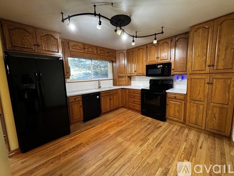 A kitchen with wooden cabinets and black appliances.