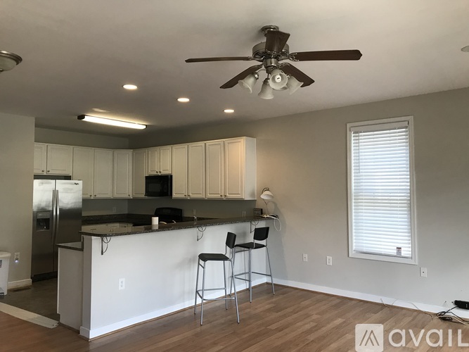 A kitchen with a bar and two stools.