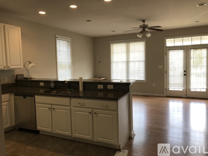 A kitchen with white cabinets and a black countertop.