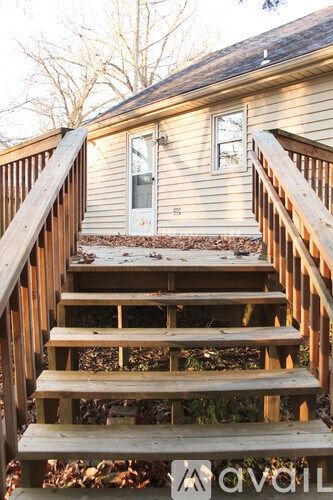 A wooden staircase leading to a door on a house.