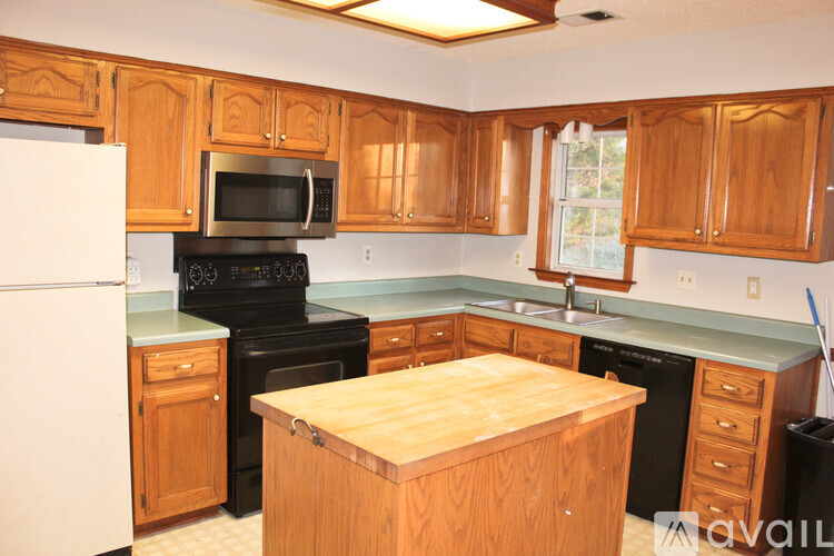 A kitchen with wooden cabinets and a white refrigerator.