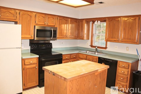 A kitchen with wooden cabinets and a white refrigerator.