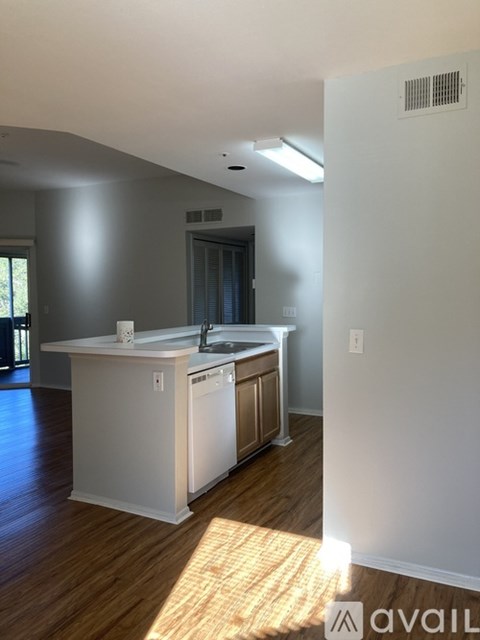 A kitchen with a white counter and a dishwasher.