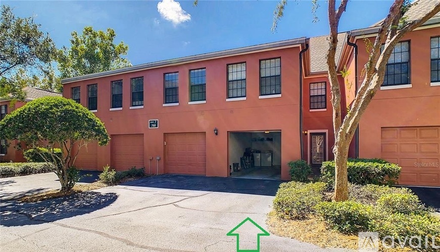 A red building with a green arrow pointing to the front door.