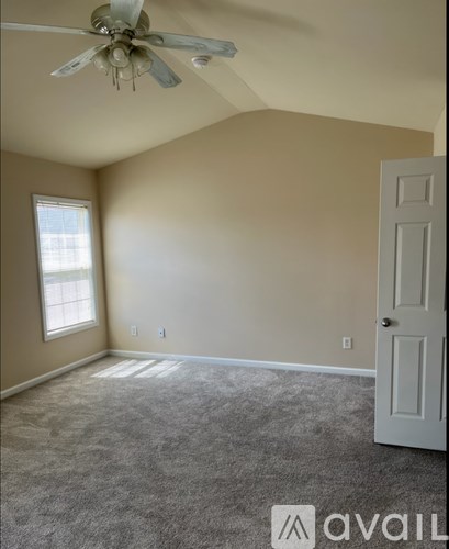 A room with a ceiling fan and a door.