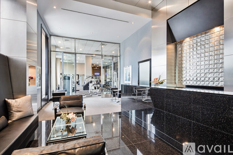 A spacious lobby with a glass table and leather couches.