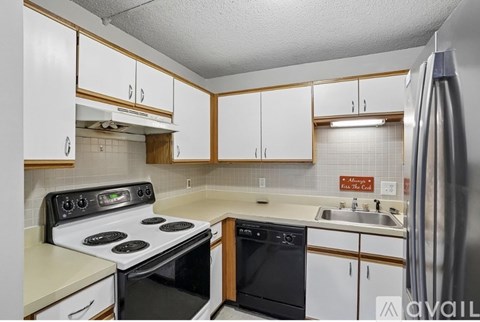 A kitchen with white cabinets and a black stove top oven.