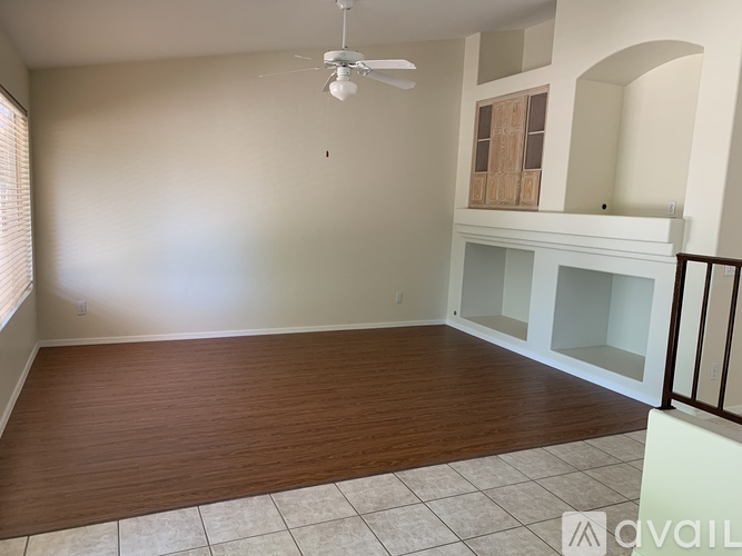 A room with a fireplace and a fan on the ceiling.