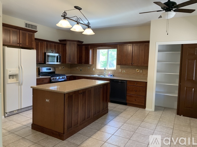 A kitchen with brown cabinets and a white refrigerator.