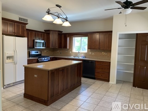 A kitchen with brown cabinets and a white refrigerator.