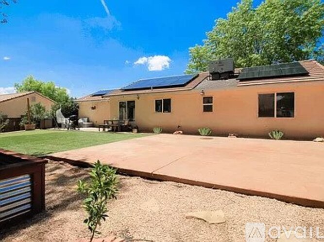 A house with a brown exterior and solar panels on the roof.