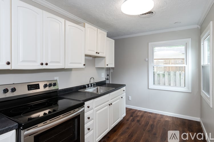 A kitchen with white cabinets and a black stove top oven.