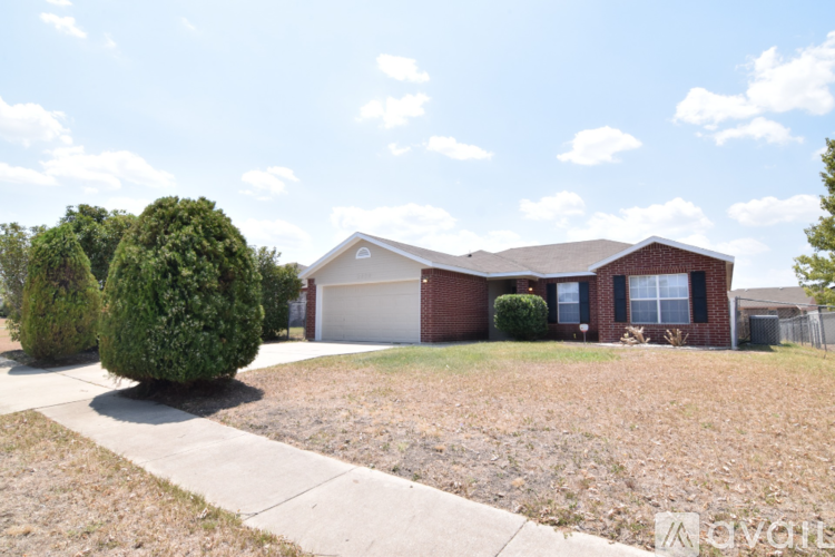 A house with a brown roof and a white garage door is for sale.