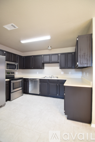 A kitchen with black cabinets and stainless steel appliances.
