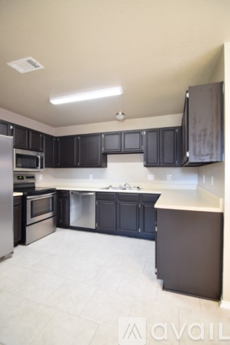 A kitchen with black cabinets and stainless steel appliances.