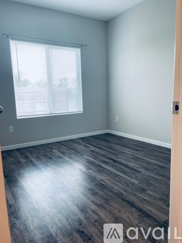 A room with a window and wooden flooring.