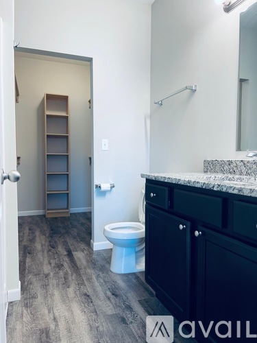 A bathroom with a toilet, sink, and a cabinet.
